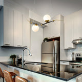 VONN Artisan Chianti 43" Integrated LED Pendant in Antique Brass VAC3122AB over a kitchen island