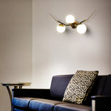 VONN Chianti 39-inch 3-Light Antique Brass Wall Sconce over a sofa
